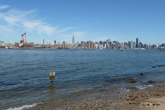 Vista di Manhattan da Williamsburg, Brooklyn. C'è una bella spiaggetta ma l'acqua non è molto attraente. Il cartello dice "Scemo chi legge"